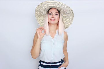 Young blonde woman with big white summer hat