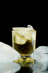 Chilled alcoholic cocktail with ice on black background