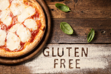 A gluten free pizza on  a rustic wood background