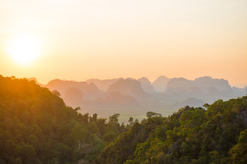 Fototapeta na wymiar Beautiful landscape with dramatic sunset, tropical rainforest and steep mountain ridge on horizon. Krabi, Thailand