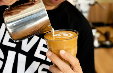 Barista is decorating latte coffee.