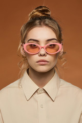 Cropped front view shot of blonde lady, wearing shirt. The girl with ballet bun and wavy hair locks...