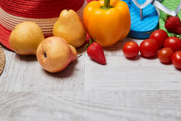 Composition of seasonal vegetables and fruits beside summer accessories. Close up. Food blogging concept