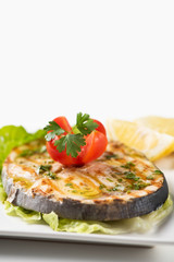 Grilled wordfish with salad and lemon on the white plate