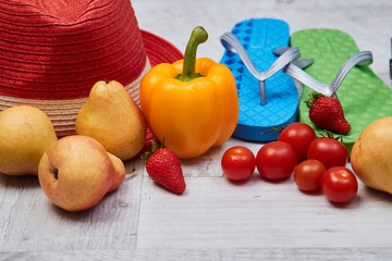 Composition of seasonal vegetables and fruits beside summer accessories. Close up. Food blogging concept