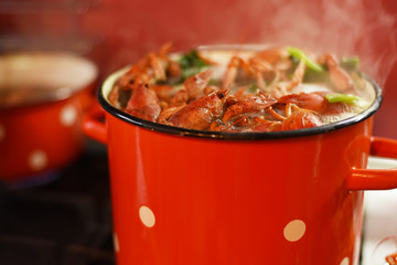 Crayfish are cooked in a large red saucepan. Cooking crayfish.