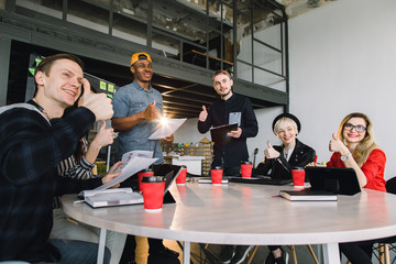 Group Young Business People Gathered Together Discussing Creative Idea. Group of international students sitting at table with coffee and computers and talking