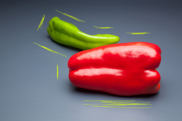 Pimiento verde y pimiento rojo, sobre fondo gris