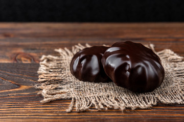 Chocolate marshmallow on dark wooden background.