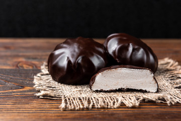 Chocolate marshmallow on dark wooden background.