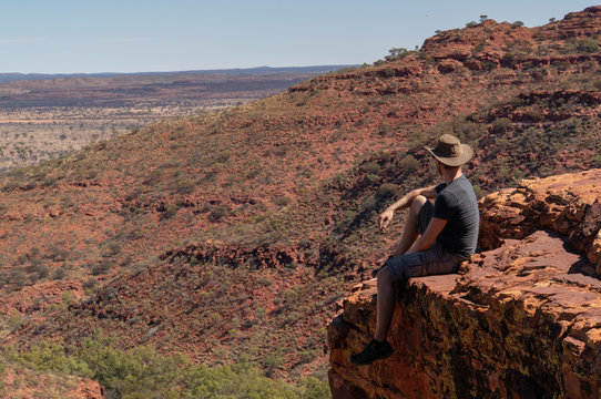 young man enyoing view of the a Canyon and standing on the edge of a cliff, Watarrka National Park, Northern Territory, Australia