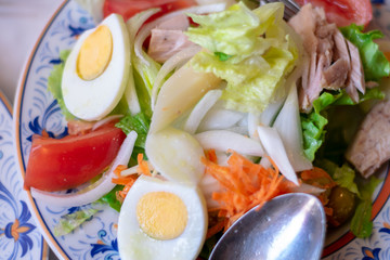 Mixed salad in a decorated plate with fork and spoon. Spanish gastronomy.
