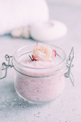 Spa and body care products. Aromatic rose bath Sea Salt, towel, candle on the grey background. Beauty skin care. Spa treatment