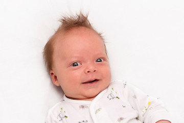 Cute Smiling newborn baby boy. Adorable infant looking at camera.