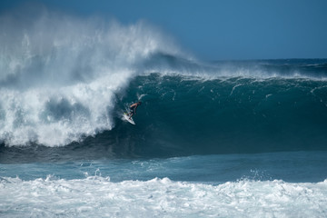 Surfer rides giant wave at the famous Banzai Pipeline surf spot located on the North Shore of Oahu in Hawaii