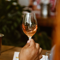 Glass of rose and white wine seen in close hand.