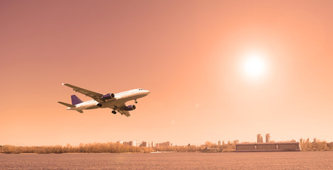 Plane over the river in cloudy weather in the city. Travel, tourism.