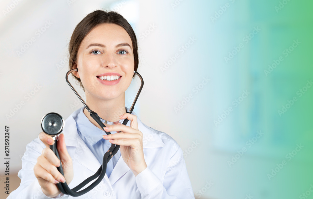 Wall mural Portrait of an attractive young female doctor in white coat