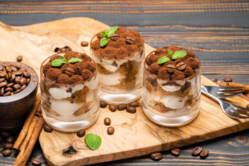 Classic tiramisu dessert in a glass on wooden background