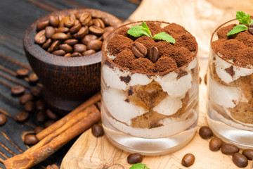 Classic tiramisu dessert in a glass on wooden background
