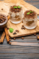 Classic tiramisu dessert in a glass on wooden background