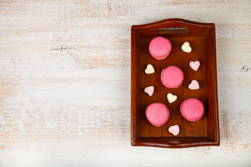 Strawberry macarons and marshmallows on a tray