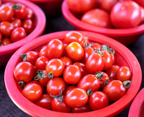 Delicious fresh tomatoes fruit vegetable food in red plastic basket at tradition market afternoon, Seoul, South Korea, harvest concept, close up.