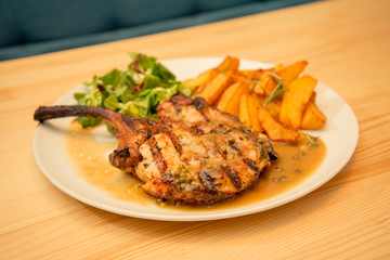 Plate of mutton steak or chops with potato and sauce garnish