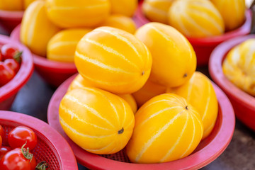 Delicious korean stripe yellow melon fruit food in red plastic basket at tradition market afternoon, Seoul, South Korea, harvest concept, close up.