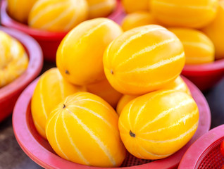 Delicious korean stripe yellow melon fruit food in red plastic basket at tradition market afternoon, Seoul, South Korea, harvest concept, close up.