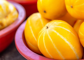 Delicious korean stripe yellow melon fruit food in red plastic basket at tradition market afternoon, Seoul, South Korea, harvest concept, close up.