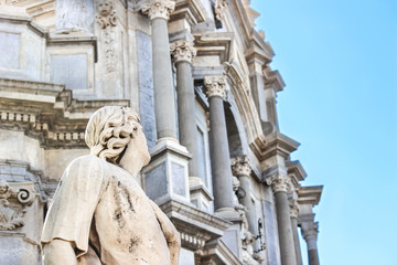 Beautiful detail of Antique statue on Catania Cathedral with blurred Roman Catholic shrine in the background. The Baroque Duomo is one of major sights in Catania, Sicily, Italy