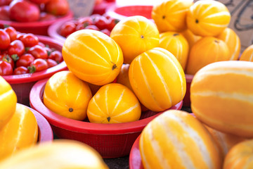 Delicious korean stripe yellow melon fruit food in red plastic basket at tradition market afternoon, Seoul, South Korea, harvest concept, close up.