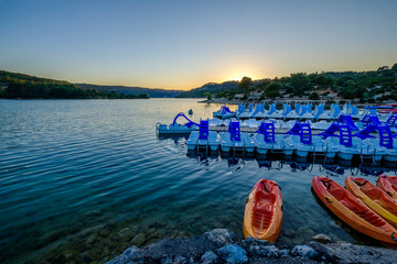 Vue sur le lac Esparron, coucher de soleil. Bateaux et kayaks sur l'eau. Provence, France, Gorges...
