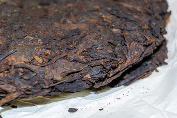 Chinese pressed puer tea on wrapping paper, close-up, macro