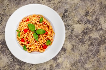 Spaghetti pasta with tomatoes and parsley on  table.