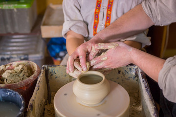 Potter showing how to work with ceramic in pottery studio