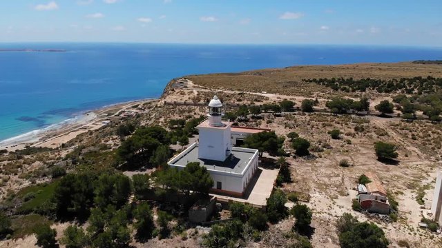 Semicircle flight landside around the lighthouse of Santa Pola in Spain near the city of Alicante overlooking the Mediterranean Sea. Sunshine and blue sky. Aerial view 4k.