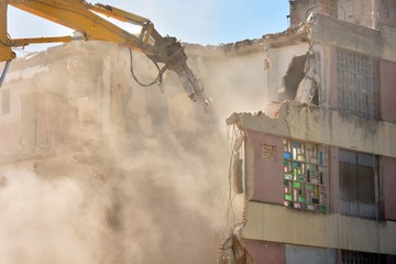 Máquina rompiendo un viejo edificio de viviendas
