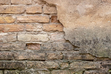 Old brick wall with peel stucco texture. Retro vintage worn wall background. Decayed cracked rough abstract wall surface