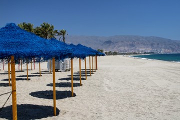 Sun umbrellas and sunbeds in the sand