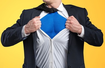 Businessman tears shirt on himself to show that he is Superman isolated on background