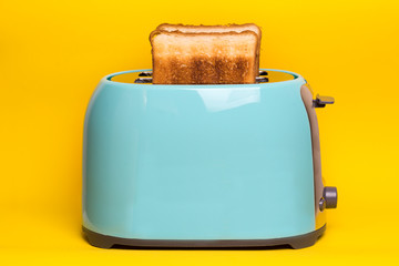 cyan color toaster on a yellow background
