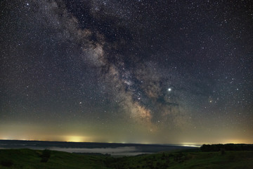 Stars in the sky at night. Bright milky way over the horizon with fog. Photographed with a long exposure.