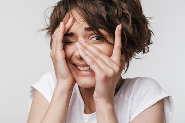 Beautiful young pretty scared woman posing isolated over white wall background.