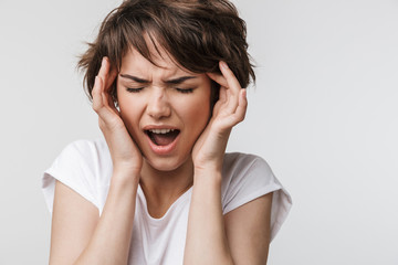 Pretty sad woman posing isolated over white wall background with headache.