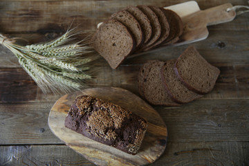​​rye bread and ears of rye on a wooden rustic background
