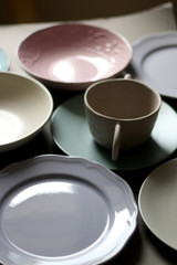 Collection of pottery and kitchenware in muted pastel colors. Selective focus.