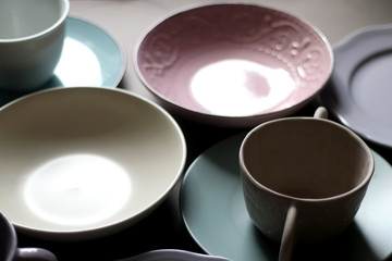 Collection of pottery and kitchenware in muted pastel colors. Selective focus.