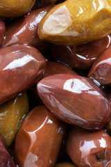 Close up marinated kalamata olives, product of Greece and Cyprus in oil as background. vertical banner. Macro.